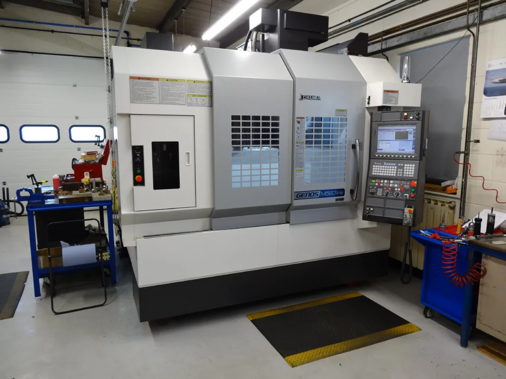 Modern CNC machine Okuma GENOS M560V-e in a well-lit workshop.